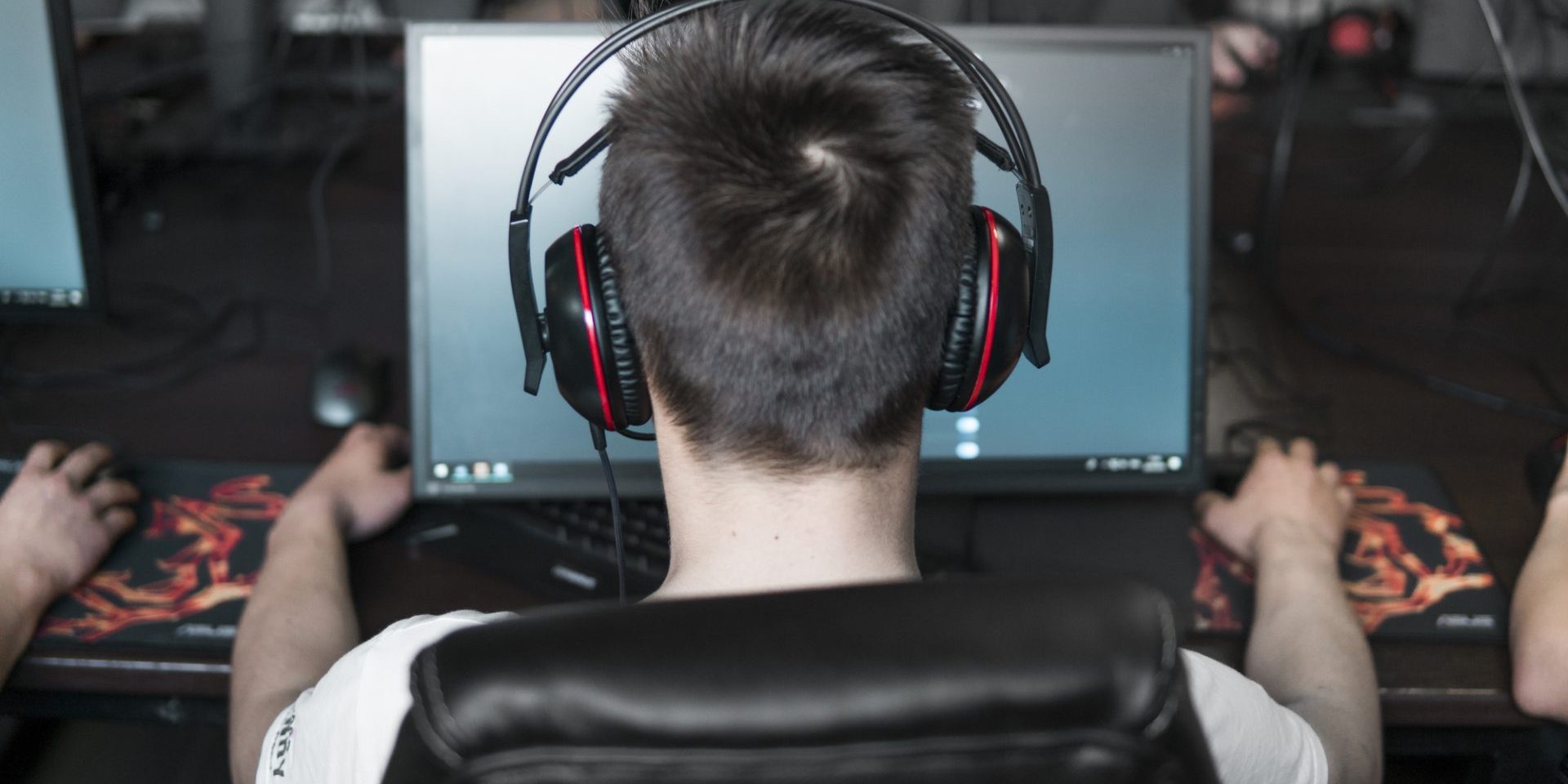 POLAND, WARSAW - June 10, 2020: Back view of young gamer in headphone playing video game at computer club