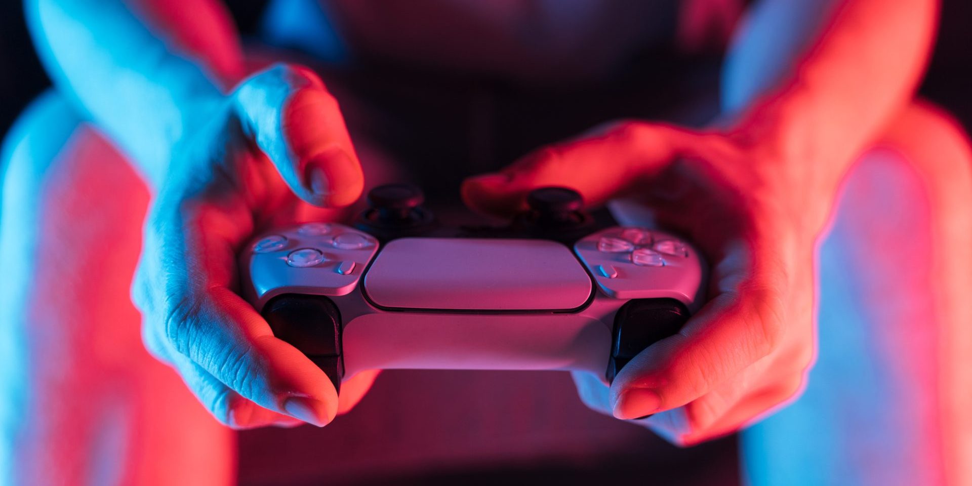 Man hands with game controller in neon light, front view. High quality photo