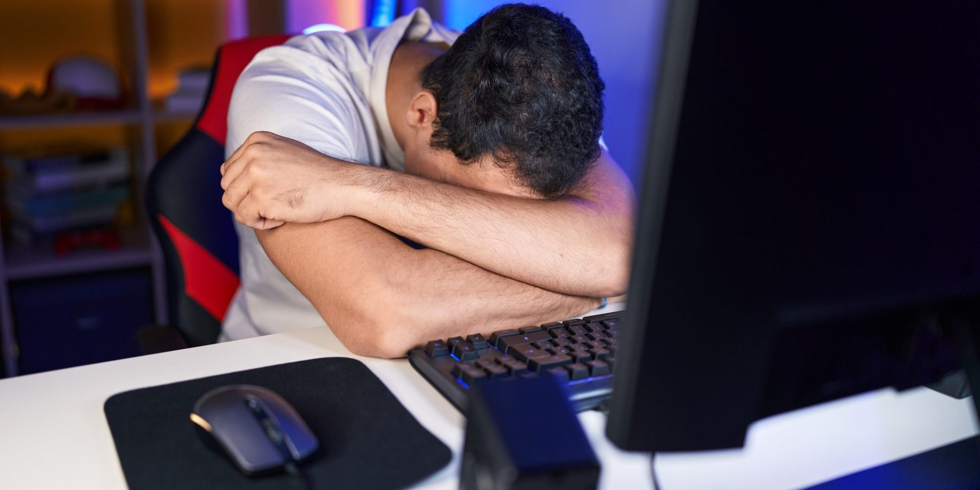 Young hispanic man streamer stressed using computer at gaming room